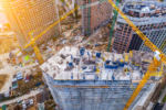 Aerial view of an active construction site showing multiple high-rise buildings mid-build, illustrating the scale of projects requiring a temporary fire alarm system.